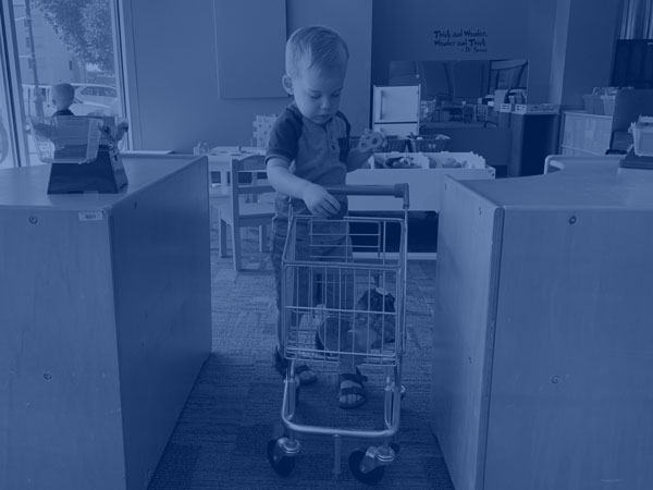 boy playing with toy shopping cart